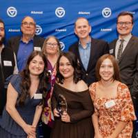 Gloria Masterton Hunter smiles with her award surrounded by friends and family